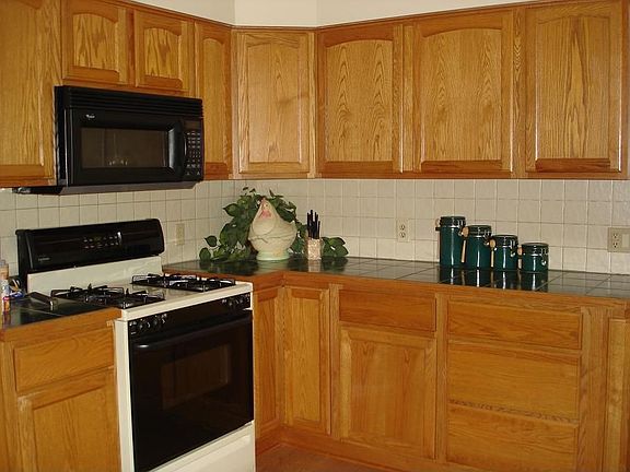 Kitchen with tile counters and back splash.