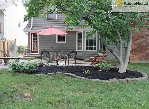 Private, shady wood fenced yard with patio, mature trees, and perennial gardens