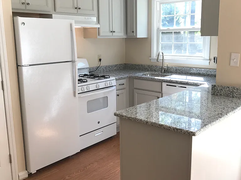 Partially renovated kitchen with upgraded wood cabinetry and granite countertops