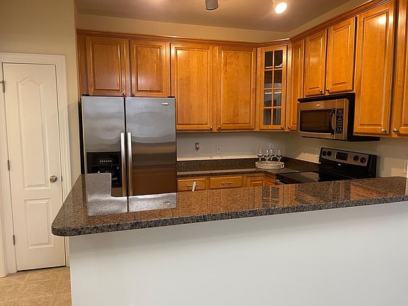 Beautiful kitchen with SS appliances, tile floor, wood cabinets, granite countertops and pantry for storage