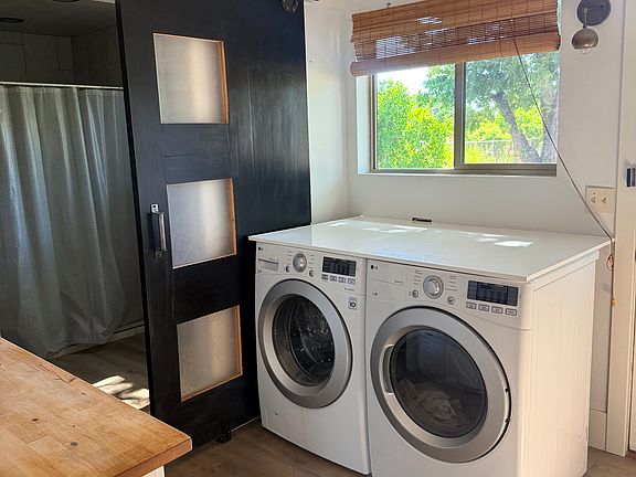 washer and dryer with counter top to fold laundry. Laundry room also has a sink for added benefits