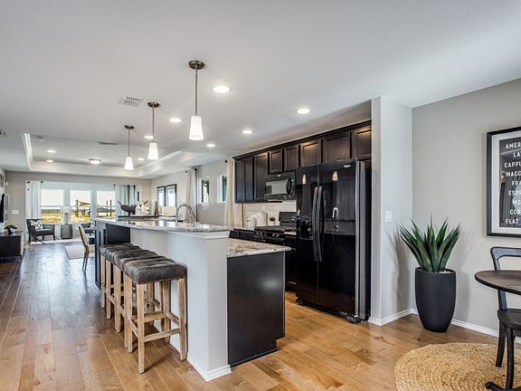 Entryway with views of the optional sunroom and island kitchen with eat-in bartop model representat
