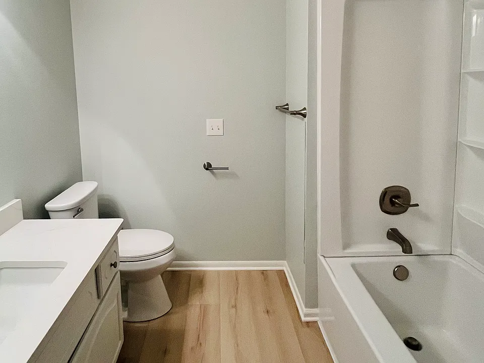Upstairs Bathroom with quartz vanity, new shower enclosure, luxury vinyl plank, and new toilet and hardware