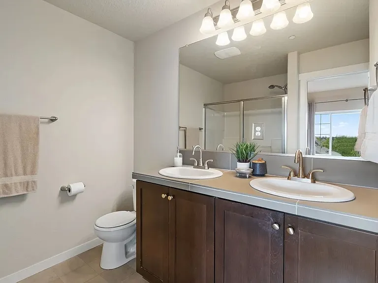 Primary bathroom with dual sinks and walk in shower
