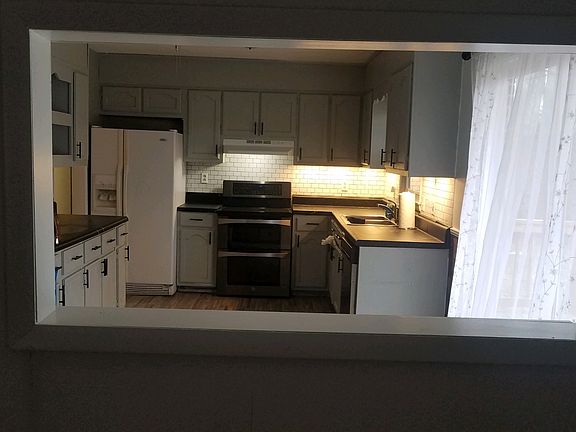 New double oven, stainless dishwasher, eat in kitchen. Under cabinet lighting. Black hardware.