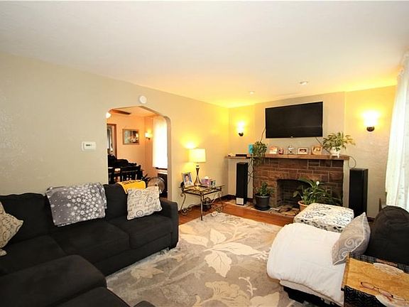 16x11 Living Room Complete with Recessed Lighting & Wall Sconces that Showcase the Decorative Stone Fireplace with Cement Mantle