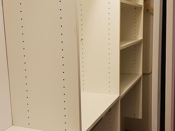 Bedroom closet with custom shelving unit. has both hanging and folding space.