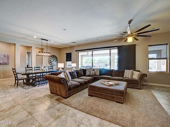 comfy furniture with space for everyone, oversized ottoman--notice the wall of windows (multi-glass slider) looking out to backyard. Indoor/Outdoor living at its best!