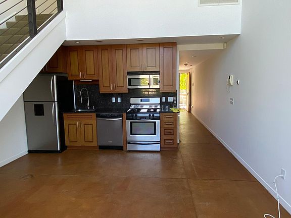 living/ dining room looking into the hallway with the open front door on view at the back