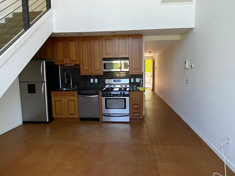 living/ dining room looking into the hallway with the open front door on view at the back