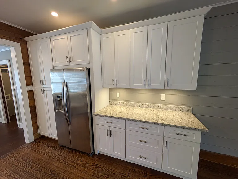 Kitchen has full height pantry cabinet, under cabinet lighting and Samsung refrigerator.