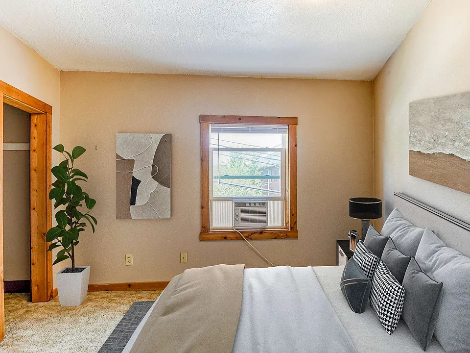 Bright, empty room with light-colored walls, a wooden accent and closet