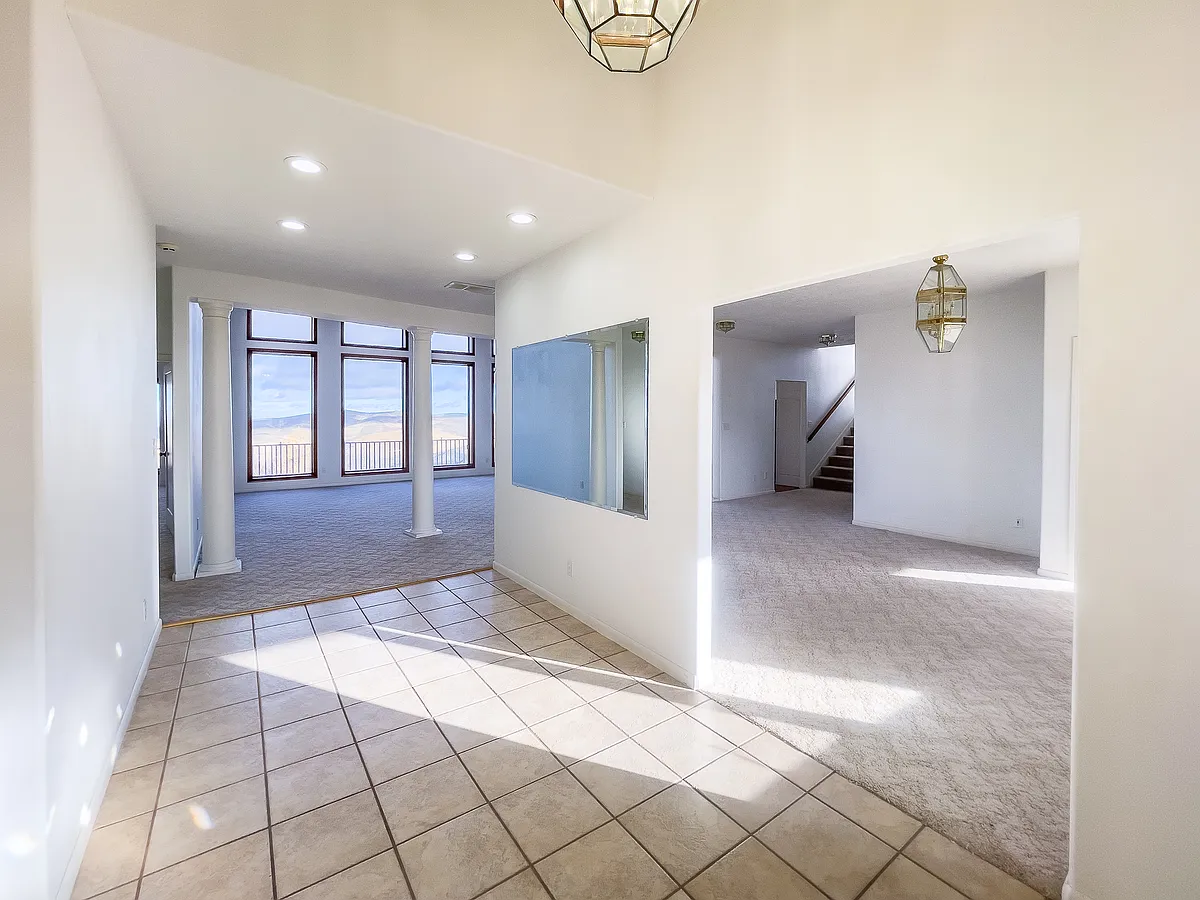 The grand foyer welcomes guests to a warm, open area with abundant natural light. - 8132 Prospector Hollow Ln