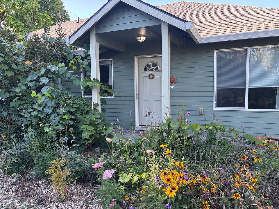 The front of the apartment view standing in the garden. There is a paved walkway from the street to the front door which is 4ft wide.