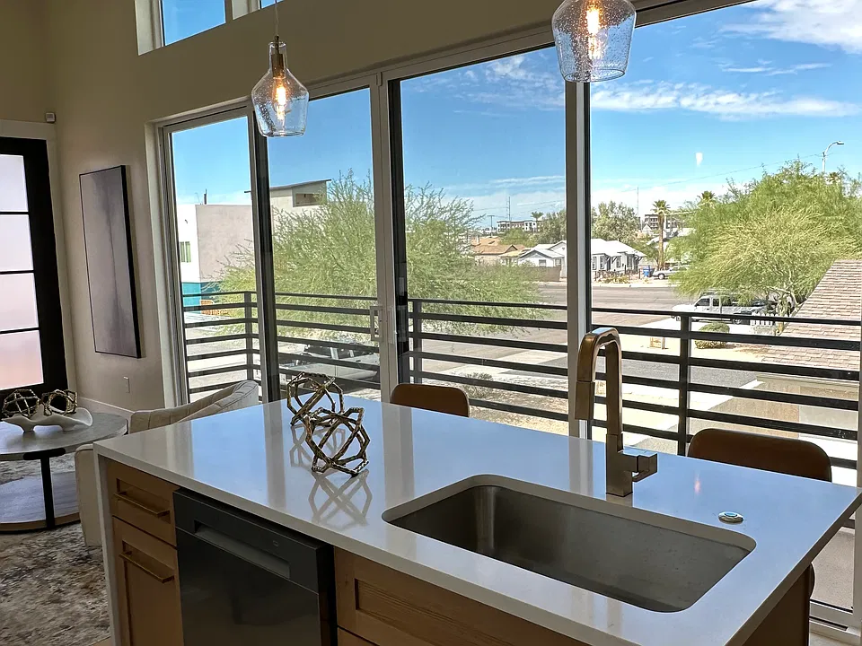 Bright kitchen with large windows, natural light, and balcony views of downtown Phoenix.