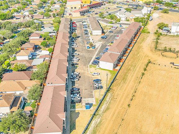 Overhead view of a residential area featuring Merida Vista Apartments and a nearby parking lot in Laredo, Texas