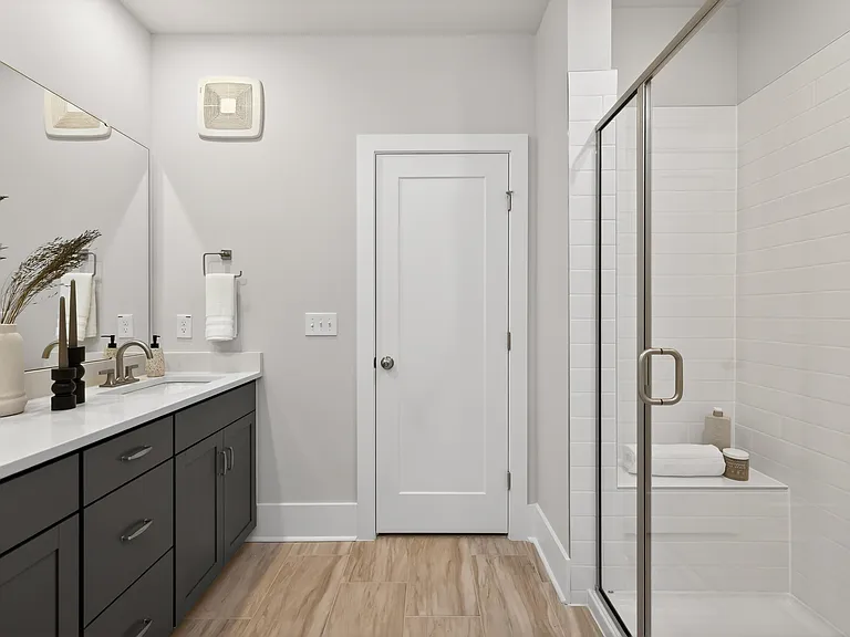 Primary en suite bathroom with dual vanities and walk in shower