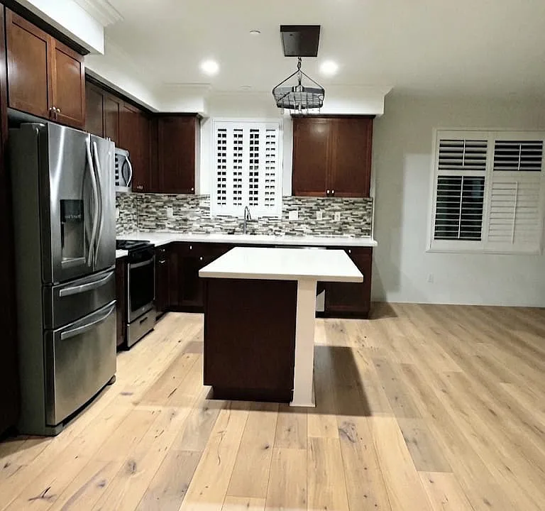 Side view of the kitchen (virtually staged to reflect updated flooring)