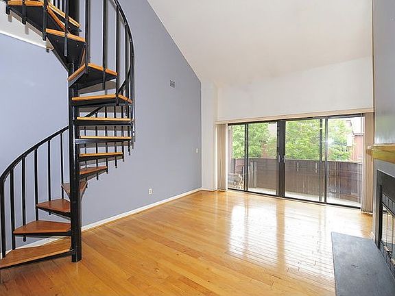Living Room with Gleaming Hardwoods, Built In Shelving and Staircase