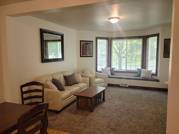 View from dining room into living room. Comfy window seat looks out on beautiful maple trees in front yard.