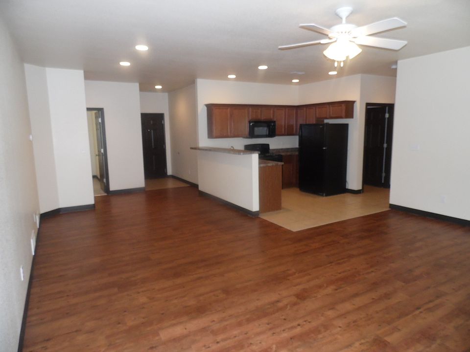 Beautiful wood laminate flooring and all black appliances in