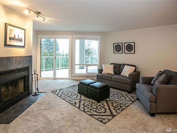 Sizable living room features slider to massive covered terrace and oversized window to allow an abundance of natural light. The window also has shades with a top-down bottom up closure to allow privacy and natural light. Wood burning fireplace and new carpet. 