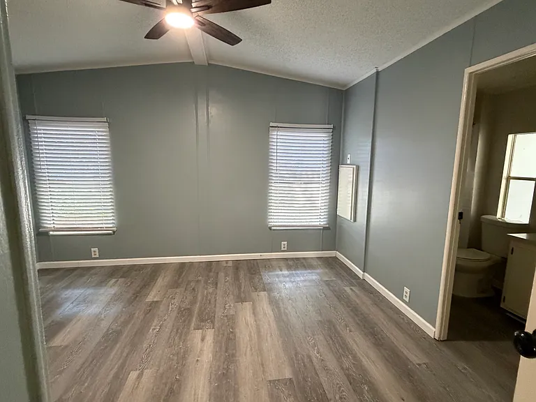 master bedroom with ensuite bath ceiling fan with remote and walk in closet