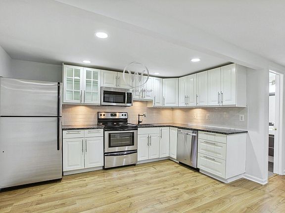 Kitchen w/ White Cabinetry & SS Appliances