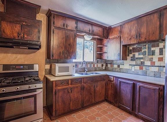 Updated kitchen with stainless steel appliances, gas stove, natural stone counters and backsplash.