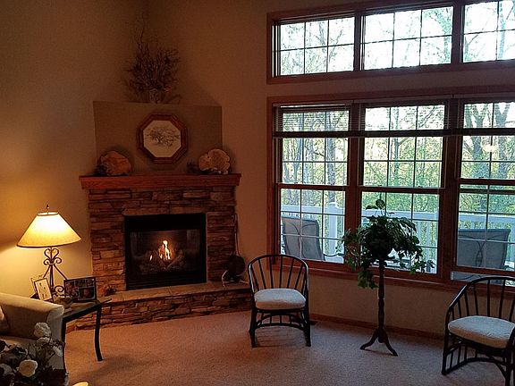 This is the living room, with a 12' ceiling, a wall of west facing windows, and a gas fireplace.