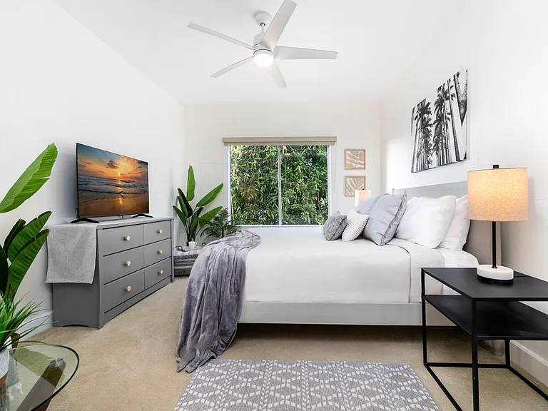 King bedroom with West Elm furnishings, Casper Wave mattress, 50" Smart TV, and ocean peek.