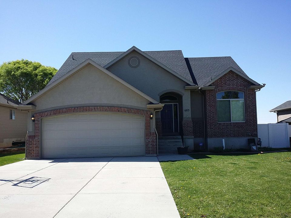 front of the house with a basketball hoop on the driveway