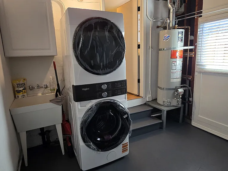 Spacious garage with upgraded hot water heater and door out to the side yard.