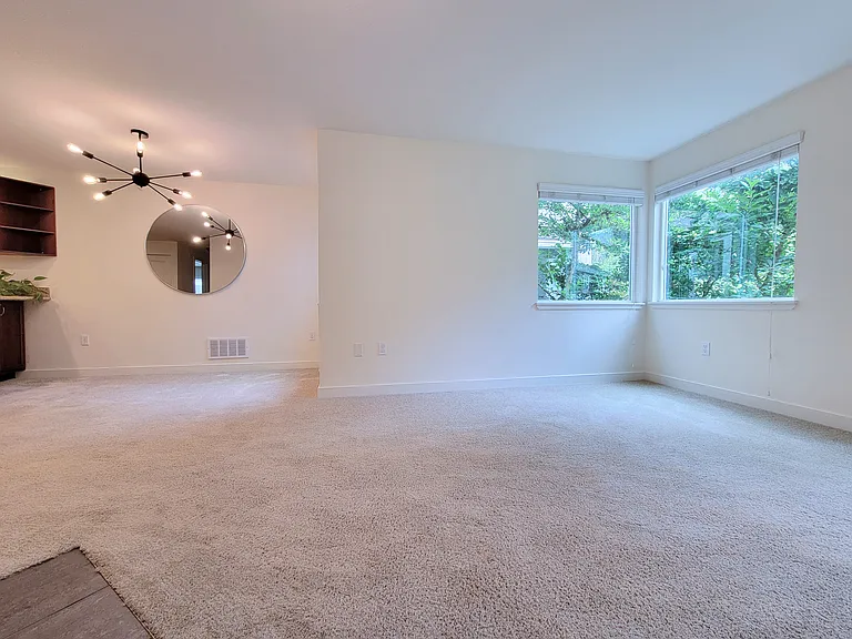 Kitchen bar and dining area, and living space flow naturally into each other. Mature magnolia tree outside the window.