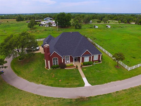 Concrete drive and white vinyl fencing on this beautiful 5 acre property.