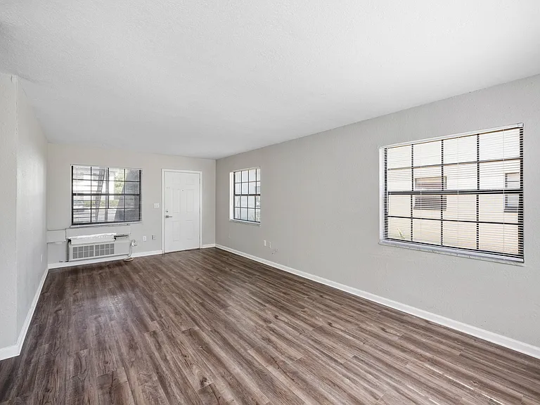Spacious and bright living area with elegant wooden floors, large windows, and modern finishes.
