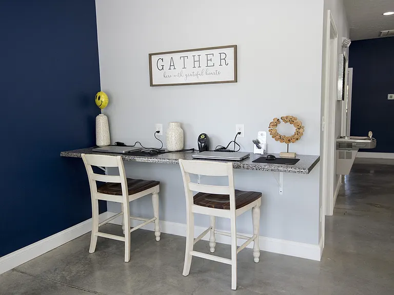 Chic workspace with granite countertop, stylish decor, and inviting chairs against a navy blue accent wall.
