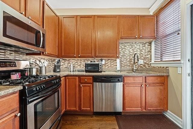Kitchen has all stainless steel dishwasher, range, microwave, garbage disposal and refrigerator. Glass tile backsplash with granite counters.