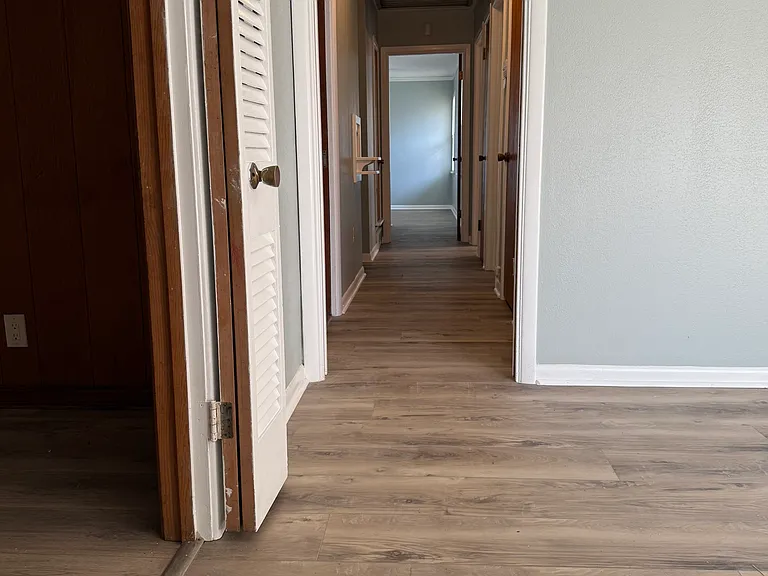 Looking down the hallway from the living room past the bedrooms, bath and into the master bedroom.