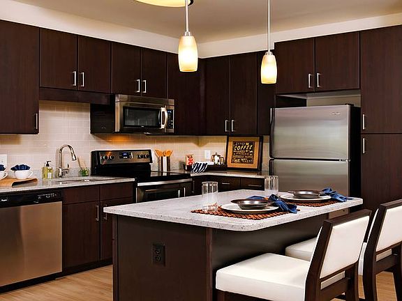 Kitchen with granite countertops, stainless steel appliances, tile backsplash, island and hard surface flooring