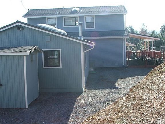View of back side of garage and home