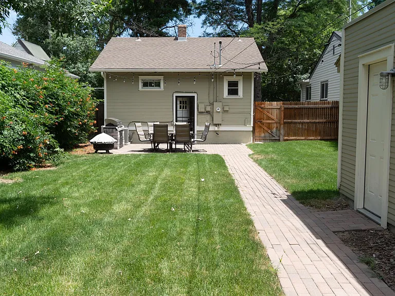The backyard walking up the sidewalk. The view is looking East. The garage side entrance is on the right.