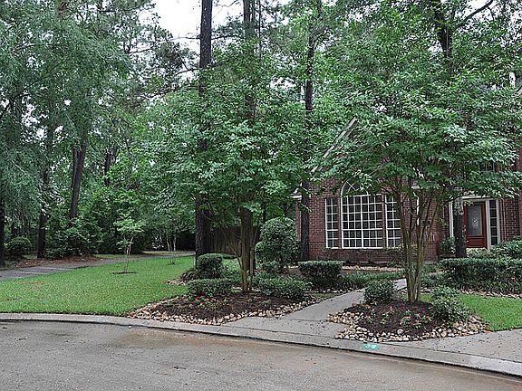 This view of shows the large side yard and beautiful mature landscaping. Walking trail adjacent to p
