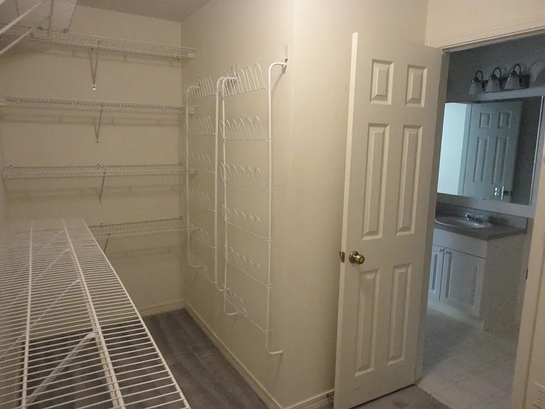 Walk in closet with tons of shelving.