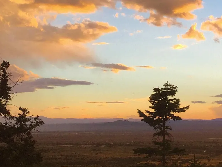 Western view at sunset, from the upper balcony showing Tres Orejas (7,976') at 17 miles and beyond; the Pedernal at Abiquiu, home of Georgia O'Keefe (9,862') at 59 miles distance.