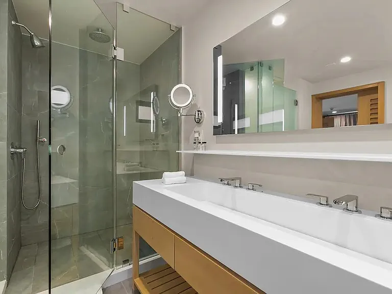 Modern, spa-style bathroom with all of your everyday essentials; hairdryer, slippers, luxurious towels, and Beekman toiletries