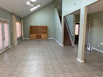 View of front doors on left and full view of the other end of the main downstairs room.