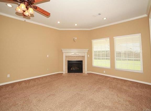 Great room with corner fireplace overlooks the back yard. Door to kitchen is on the right.