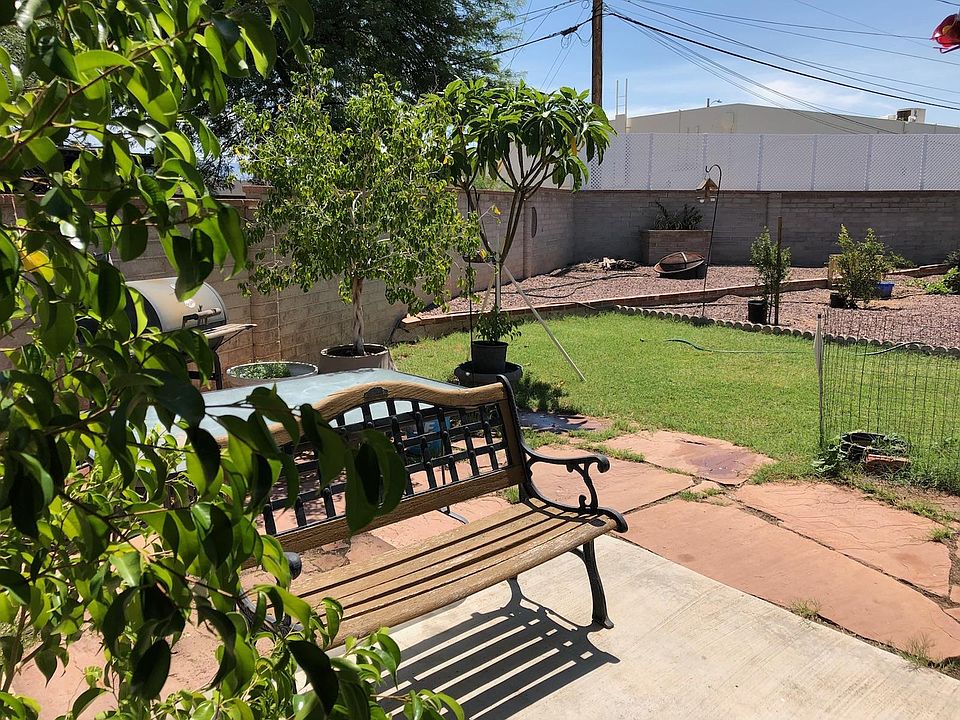 Beautifyl back yard with trees, grass, and garden area. Lan