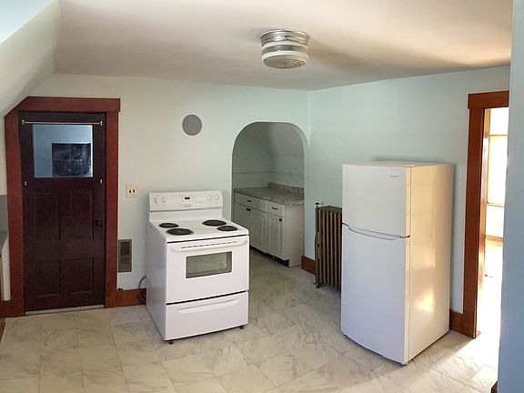 Opposite side of kitchen showing pantry space in back and doorways to back entry and sunroom
